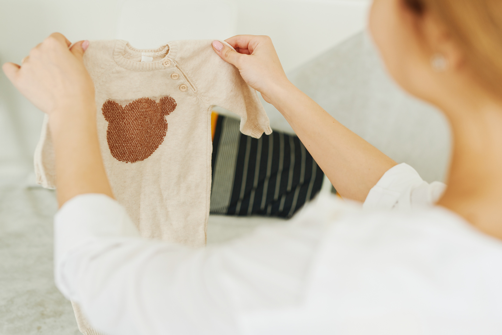 A Person Holding Baby Clothes 